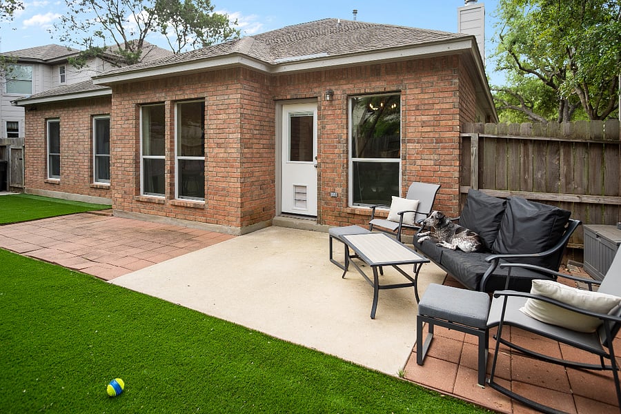 Dog door on back door that leads to yard with patio furniture to sit and watch dogs play
