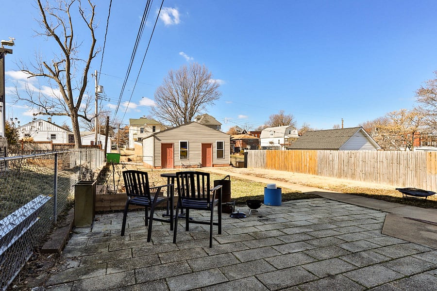 Back yard patio with 4-top teak dining set/patio umbrella in storage for summer fun. Small area for veggie garden or flowers. Charcoal grill.