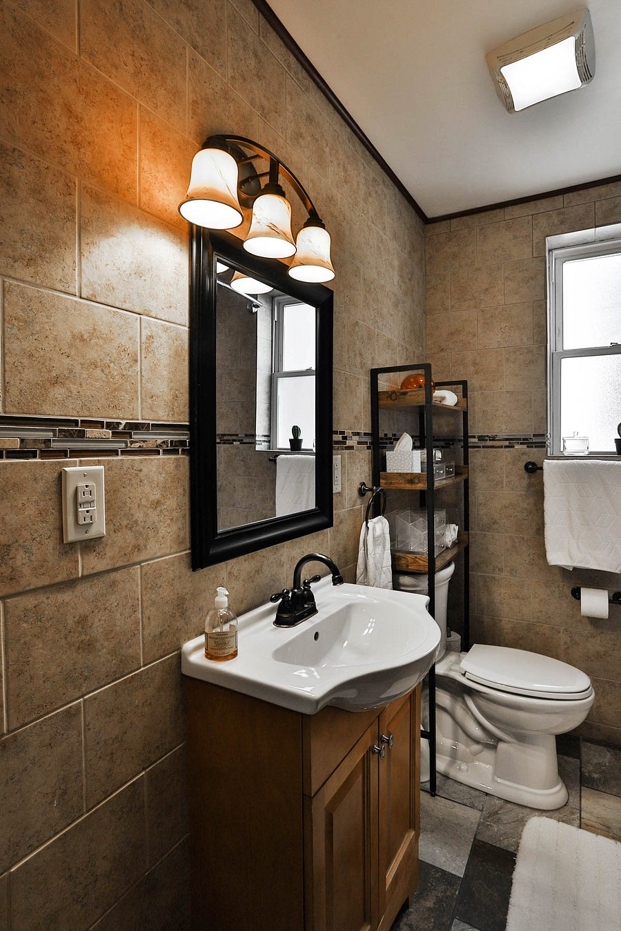 Tiled bath with linen closet and toiletry storage.