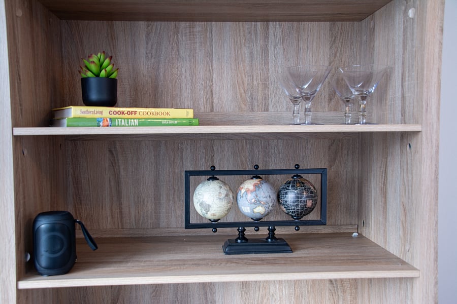 Bluetooth speaker in hutch, games, martini glasses, cookbooks.