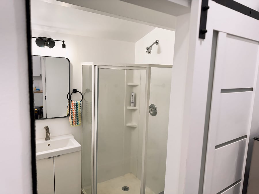 Bathroom has a beautiful barn door (lockable for security), standing corner shower, right-sized vanity, and modern fixturing.
