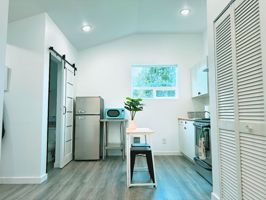 Kitchen in Daytime. Modern Kitchen w/ perfect amount of cabinet space, mid-sized fridge/freezer, microwave, stovetop, and fan.  The window brings in daylight from the north and will brighten up the room. The vaulted ceilings really make this room inviting and peaceful.
