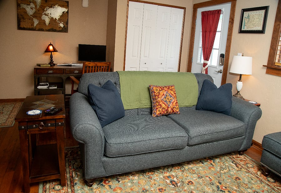 Living Room - comfortable couch, chair and ottoman, standard desk with external monitor available, office chair.