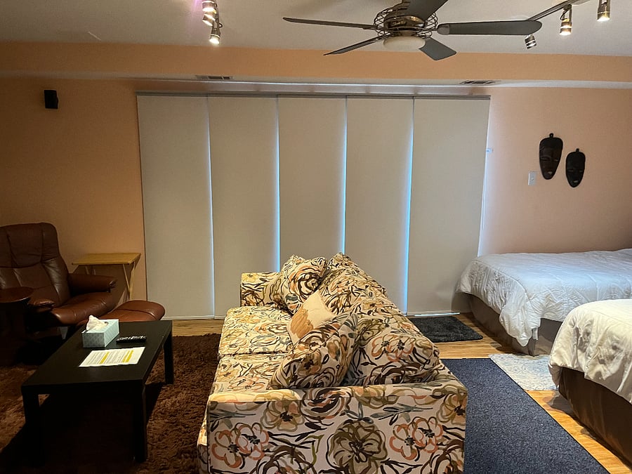 View of custom fabric panel black out curtains over sliding glass door