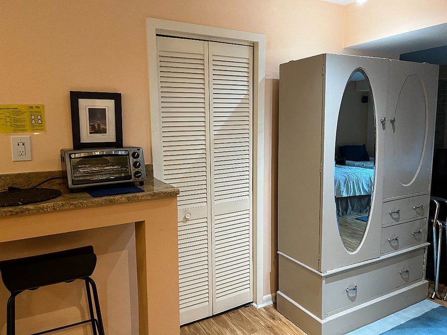 Small storage available behind the louvered doors for luggage, etc. HVAC and water heater here along with a large bookshelf for your use. Oreck vacuum cleaning, broom, Swiffer, cleaning products stored here.