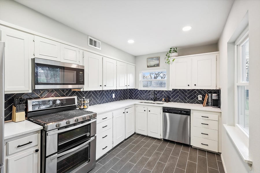 Generous kitchen, which includes a full-size fridge, gas stove/oven, microwave, dishwasher, plenty of cabinet space, and all the dishes/kitchen supplies!