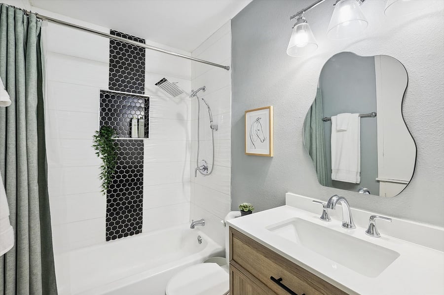 Modern and elegant bathroom, with lots of cabinet space (built into wall) and a brand new rain shower with hand-held attachment.