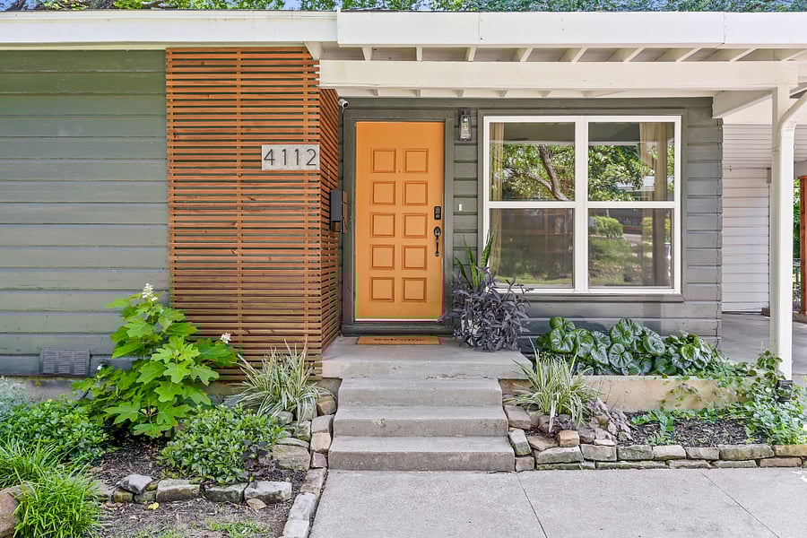 Front porch of home. Freshly renovated and modernized. Large, sweeping canopy of trees. Beautiful landscaping. Covered parking.