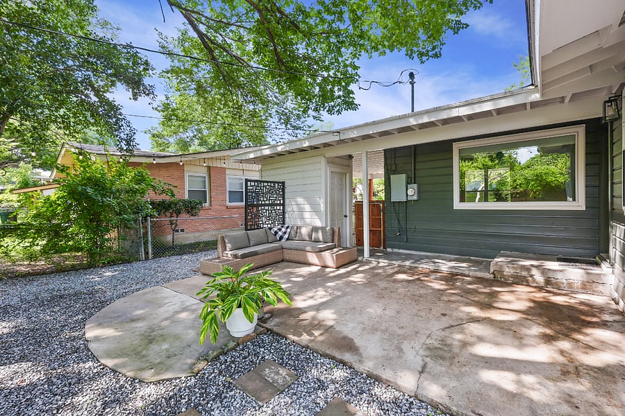 Huge backyard, with plenty of room for pets and activities! Relax on an outdoor sofa, surrounded by clean landscaping, stringed lights, and a canopy of trees!