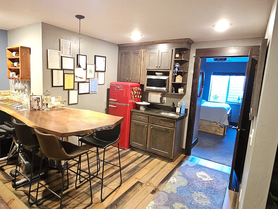 Full view of bar area and kitchenette with refrigerator.