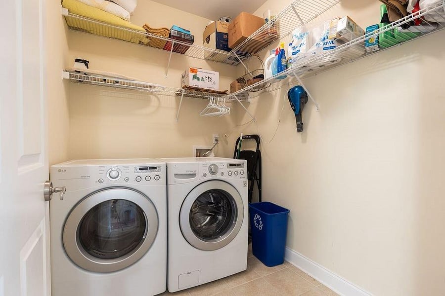 large full size washer and dryer in walk-in laundry room.