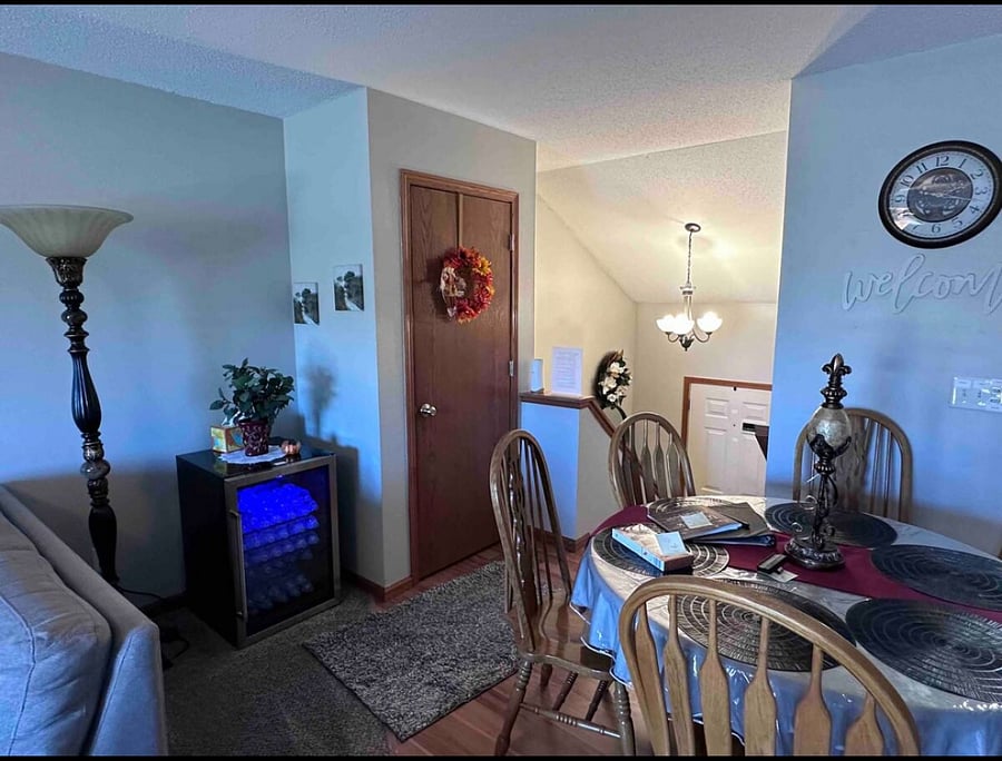 beverage refrigerator full of water, overlooking dining room to entryway