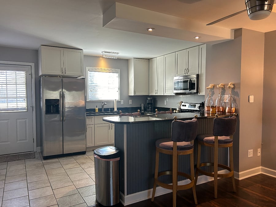 "Chef's Counter" with 4 brand new kitchen stools, super comfortable and also a great area to work. Fully stocked and updated kitchen. Washer and dryer are along the left side wall, tucked behind a sliding door, next to the downstairs half bathroom. 
