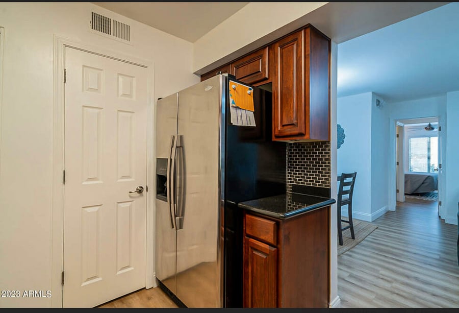 Side by side stainless fridge with large pantry in kitchn.