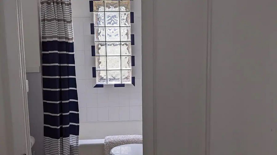 Bathroom in garden view suite of second floor flat. Tub with shower.