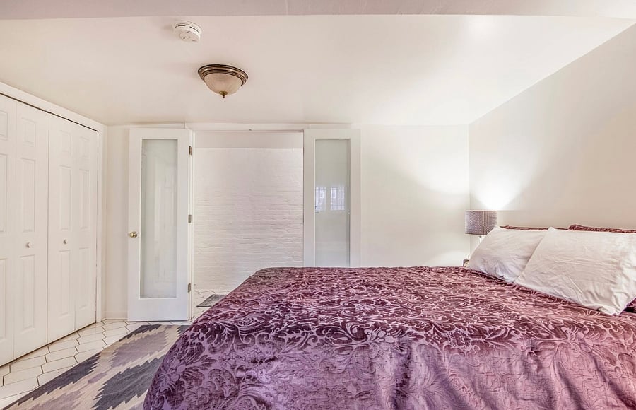 Bedroom with queen bed, dresser, and closet. Extra linens are provided.
