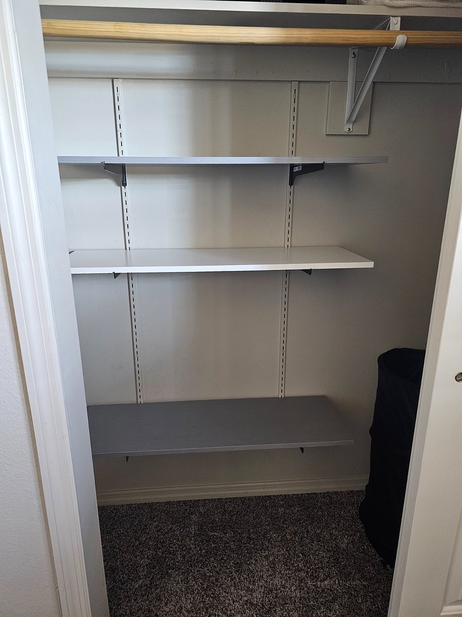 Full bedroom closet with shelves and shoe rack
