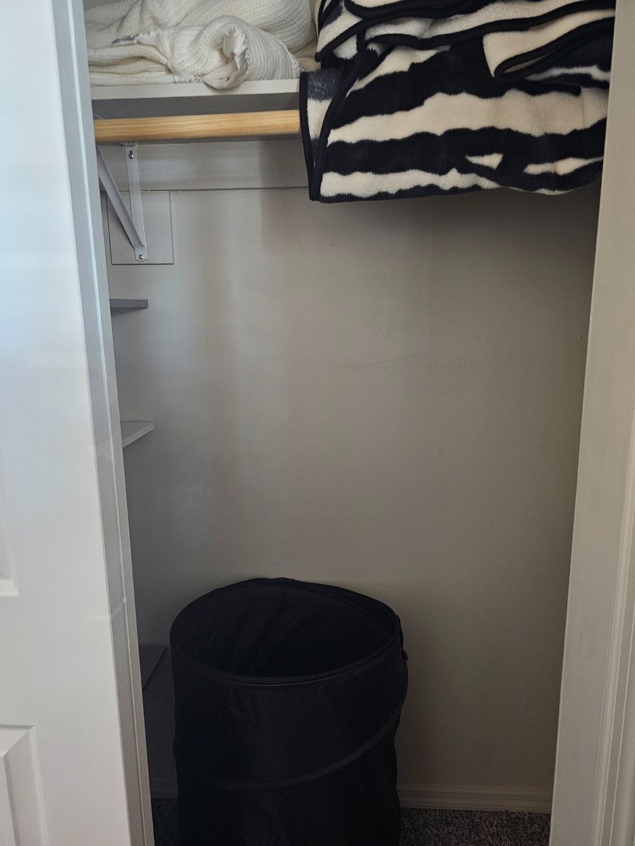Full bedroom closet with hamper
