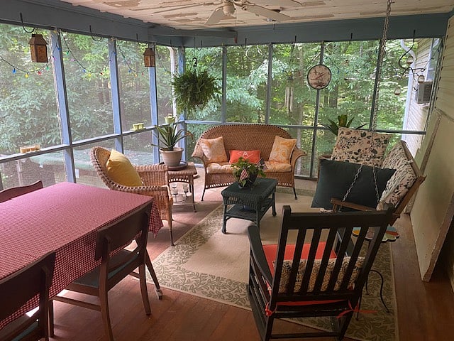 Screened in porch with dining area and outdoor workspace.