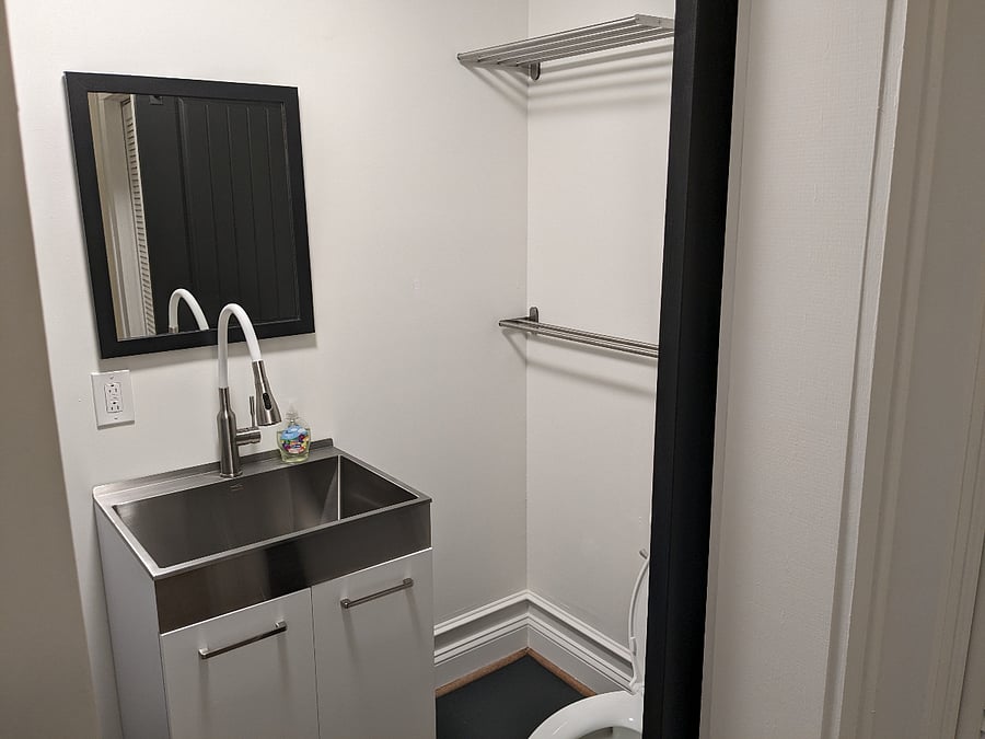 Half bathroom with toilet and laundry sink.