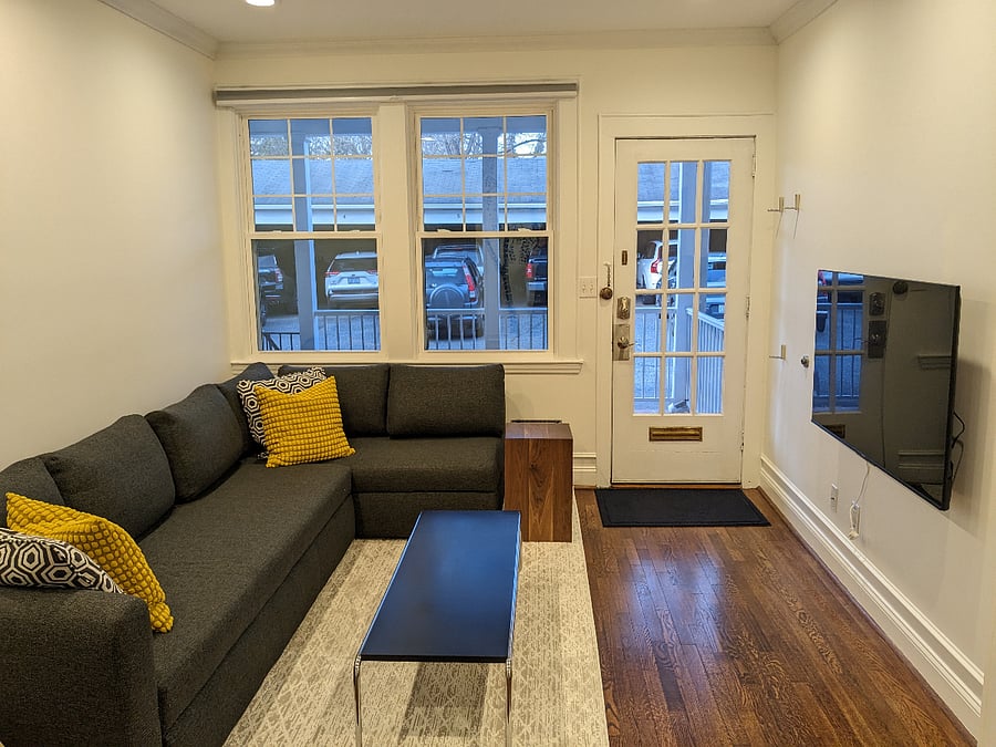Enter into the living room with large sectional sofa and smart tv.