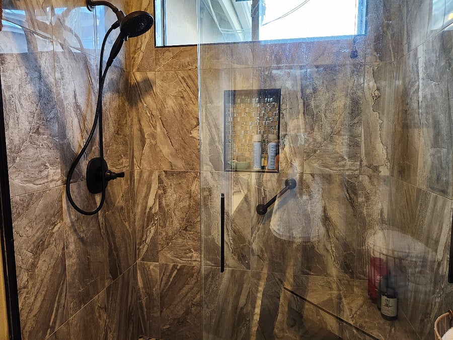 Clean, marble shower with seat/handle.