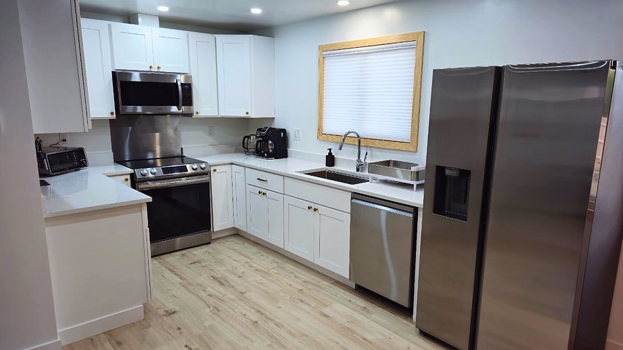 Fully equipped kitchen: stainless steel appliances, induction stovetop, 3-function coffee maker, Vitamix blender, Cuisinart food processor, cookware, Pyrex containers, travel water bottles and coffee mugs.