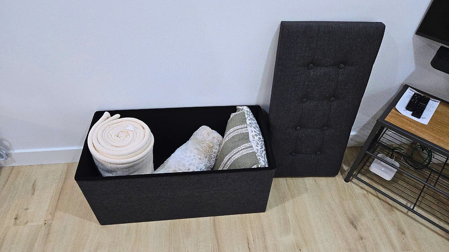 The ottoman stores extra pillows and blankets and doubles as extra seating when needed.