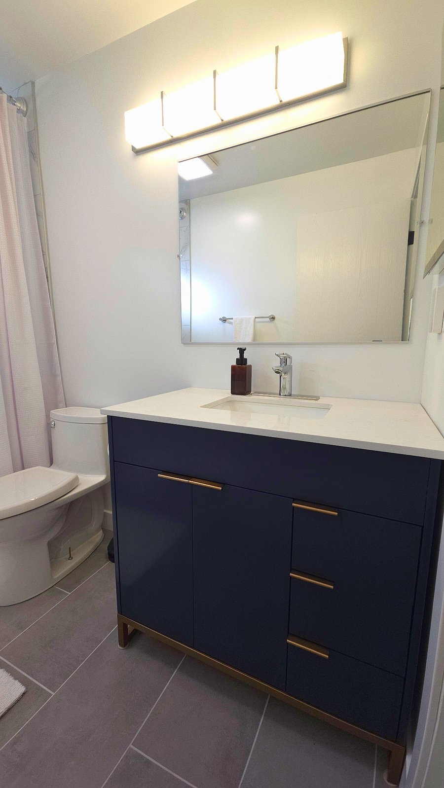 Real wood 36" vanity with quartz countertop, Hansgrohe single lever faucet. Full size mirror, medicine cabinet and plenty of storage under the sink and in the vanity drawers.