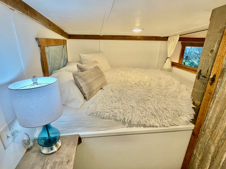 Upstairs queen sized bedroom. with closet, bench table/desk and mirror.