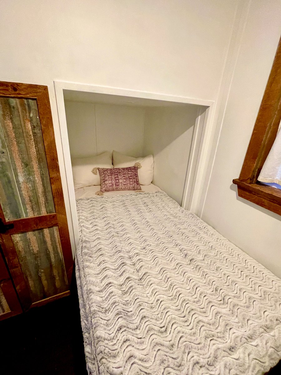 Downstairs bedroom, with twin xl bed. Closet, bookshelf nook and built in wall of shelves with built in desk