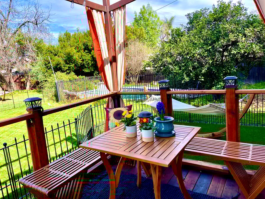 Deck table over looking the pool and back yard hammock.