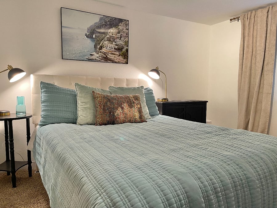 Cozy bedroom with blackout curtains. Charging stations built in to lamps.