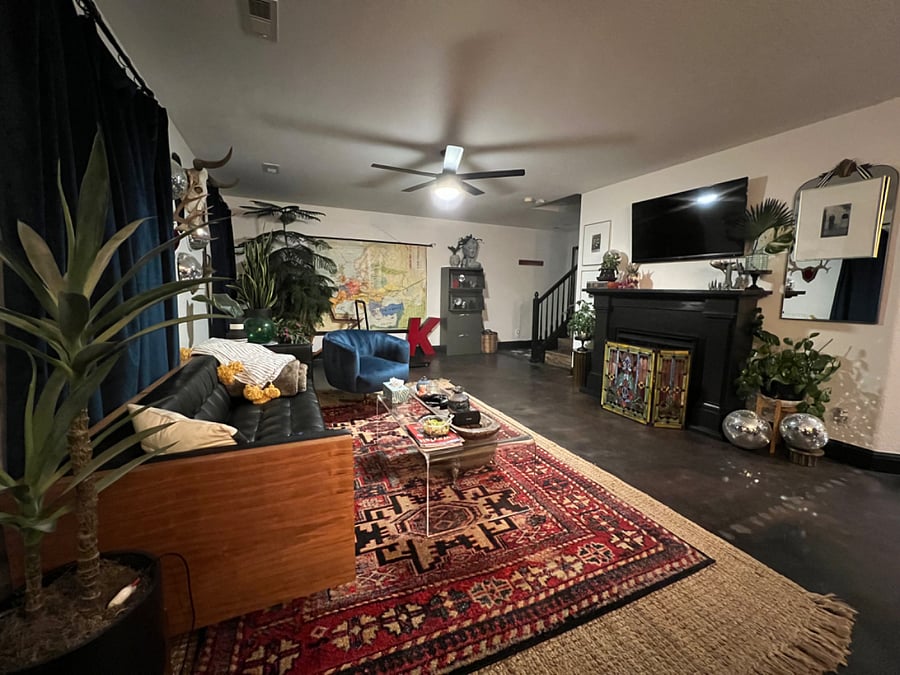 Spacious shared living/dining area with satellite TV, fireplace, exercise equipment, dining table, large windows and views into the backyard.