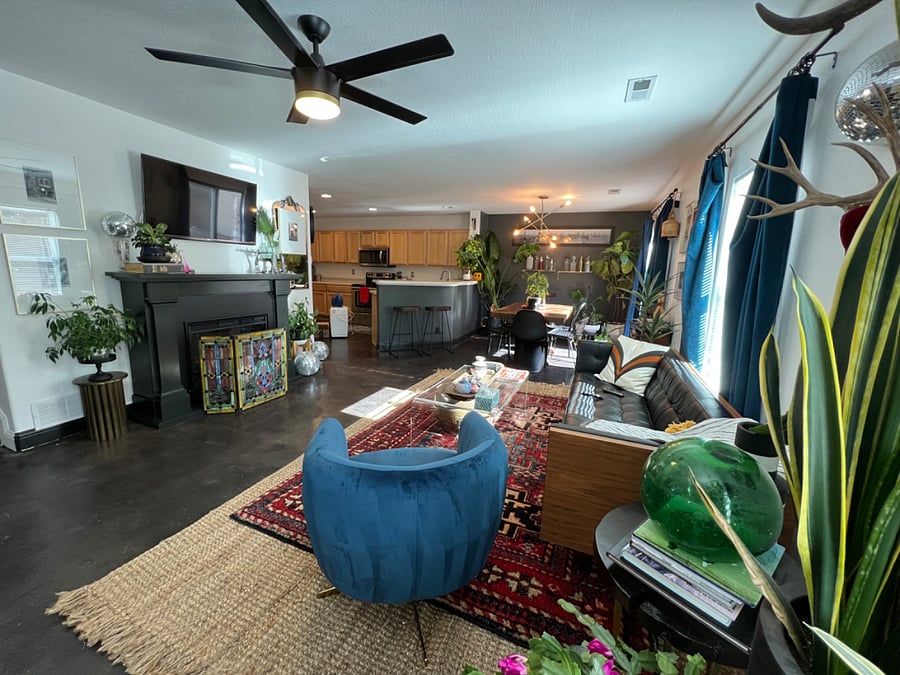 Spacious living/dining area with satellite TV, fireplace, exercise equipment, dining table, large windows and views into the backyard.