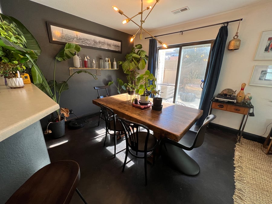 Spacious shared living/dining area with satellite TV, fireplace, exercise equipment, dining table, large windows and views into the backyard.
