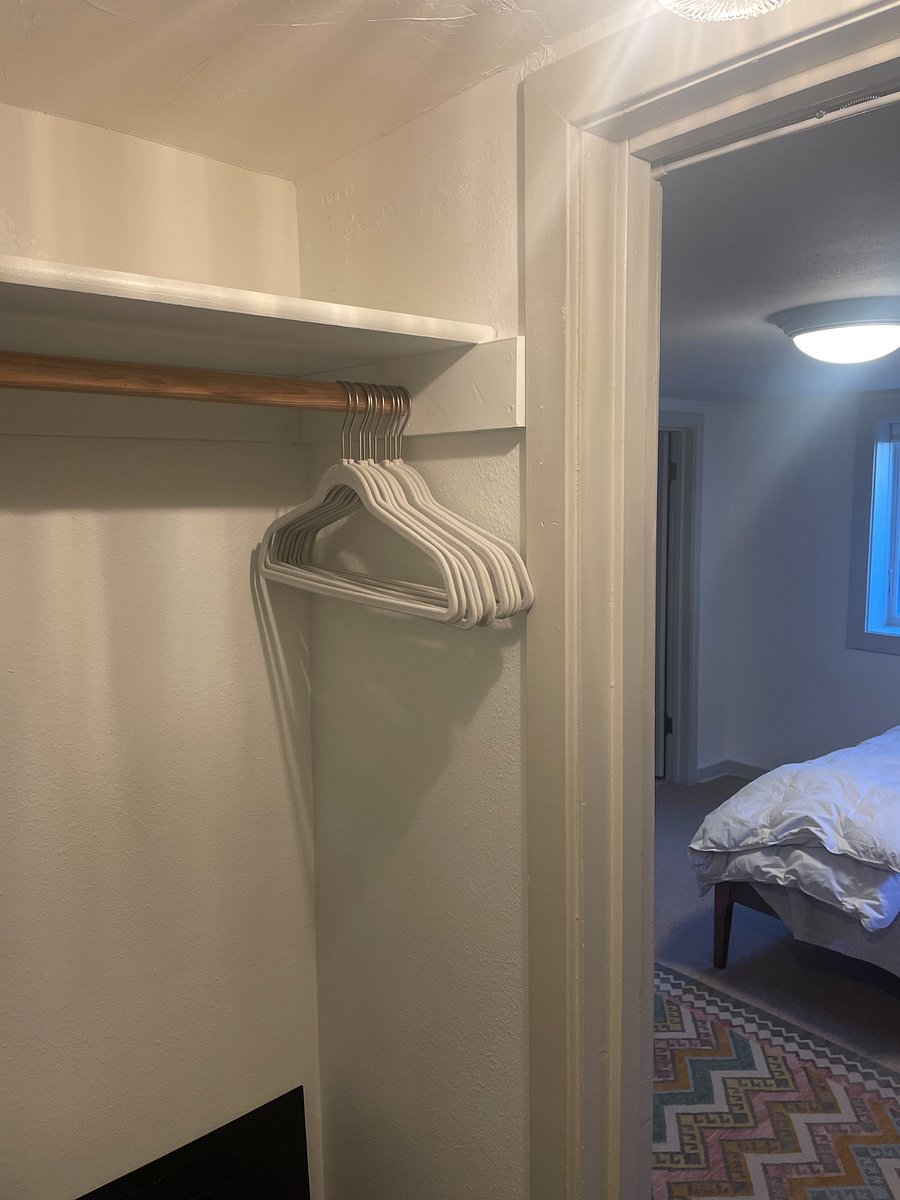 Walk-in closet in bedroom with plentiful shelves and hangers.