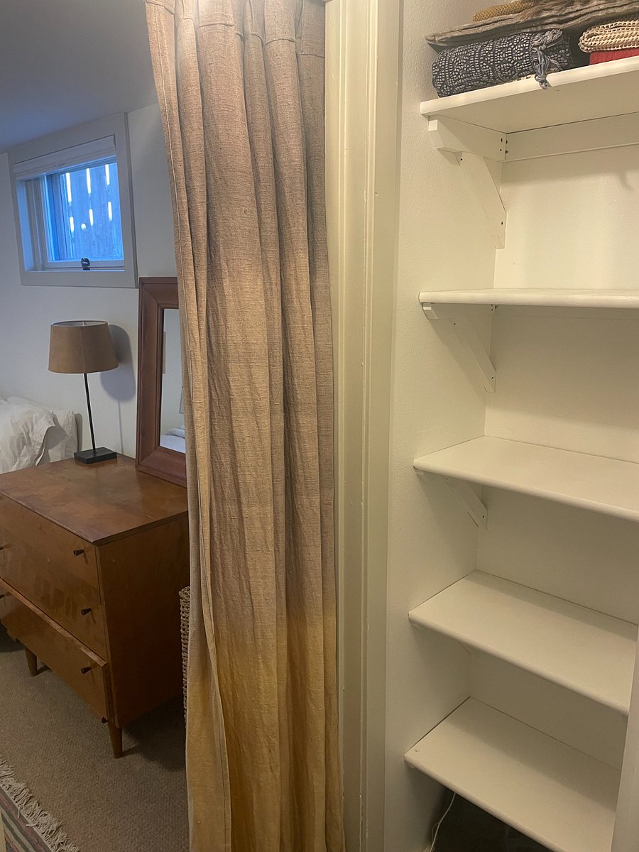 Walk-in closet in bedroom with plentiful shelves and hangers.