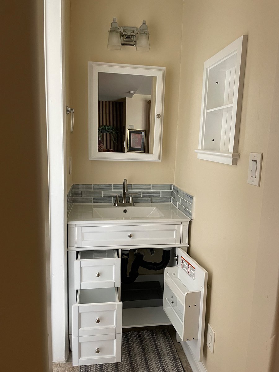 New bathroom sink and cabinet located next to bathroom. Full size medicine cabinet, and wall shelf. Lots of storage. Electrical outlets near sink for toothbrush charging or hair tools.