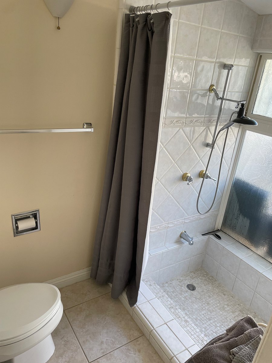 Private Large bathroom toilet area. Complete with sunken roman step-down tub with removable rain shower head. Perfect for soaking after a long day!