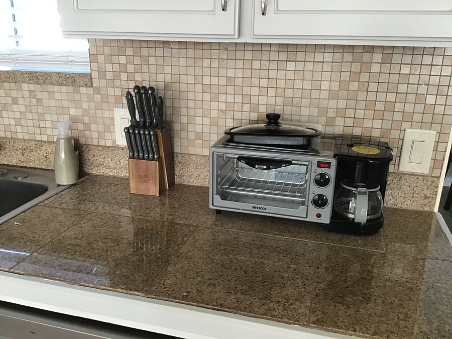 Granite tile countertops with plenty of items for food preparation. 