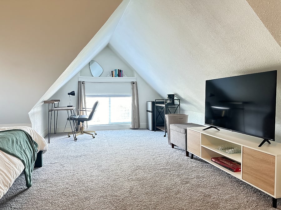 Large upstairs bedroom with desk, mini fridge and coffee maker.