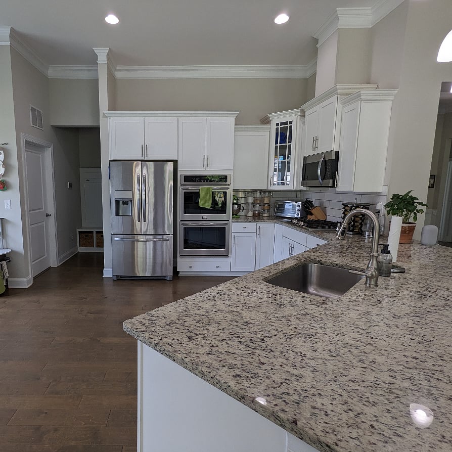 Large kitchen with double ovens and wide range of kitchen appliances.