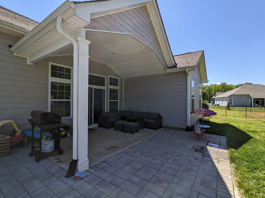 Outdoor covered patio, lounge area, and grill.
