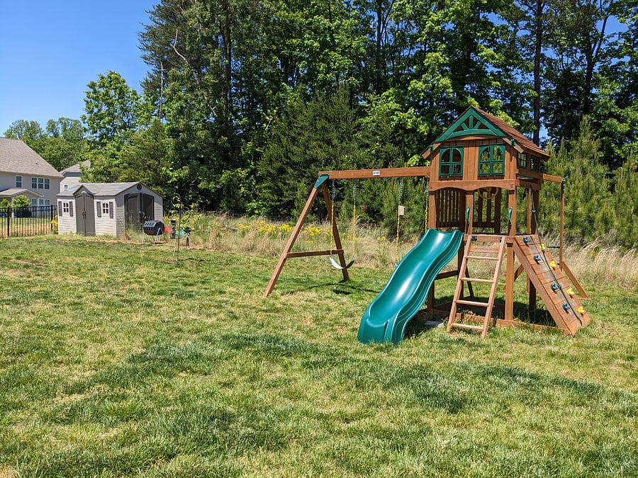 Fully fenced in backyard with play gym.