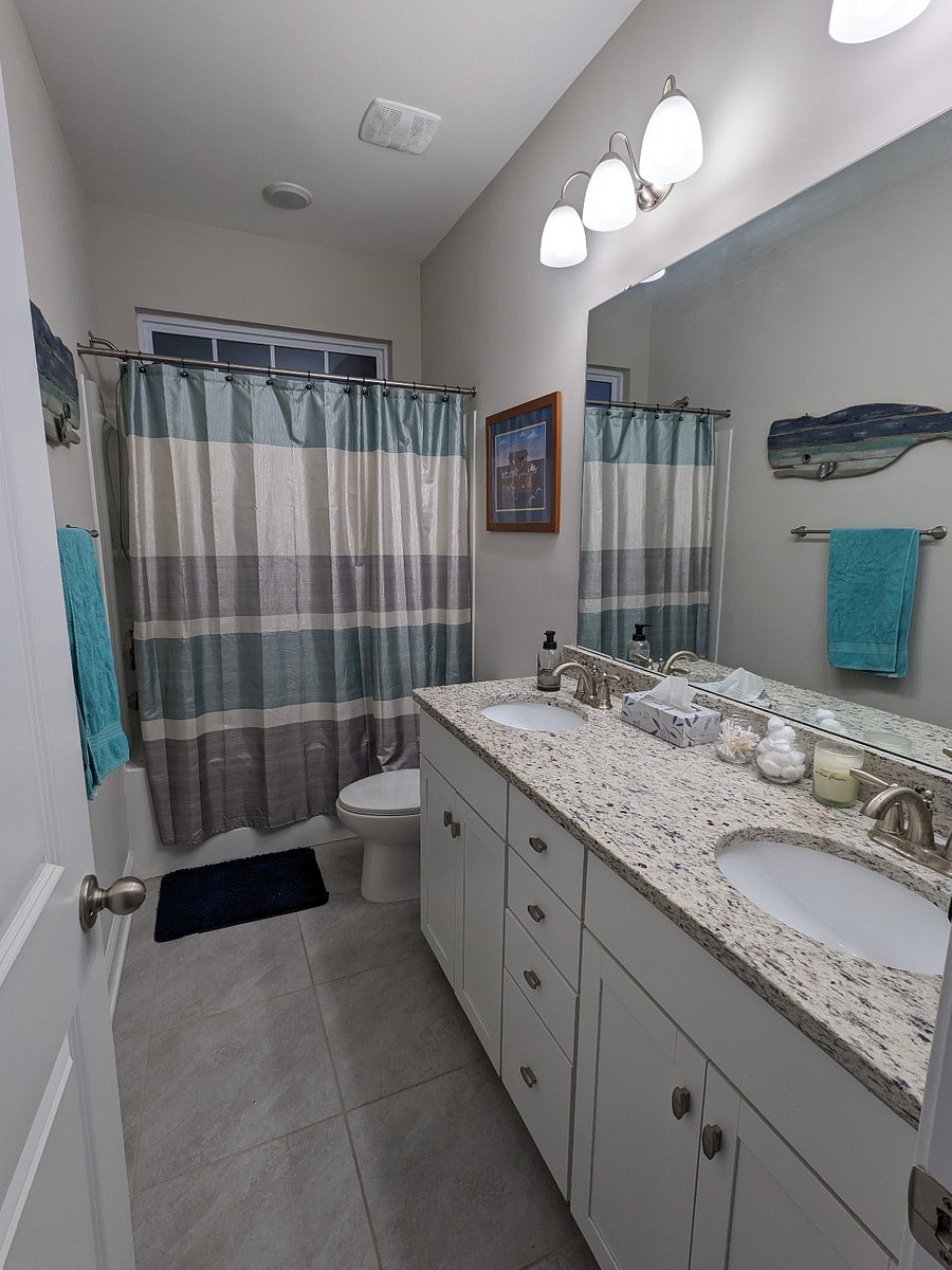 Full bathroom with bathtub and dual sinks.