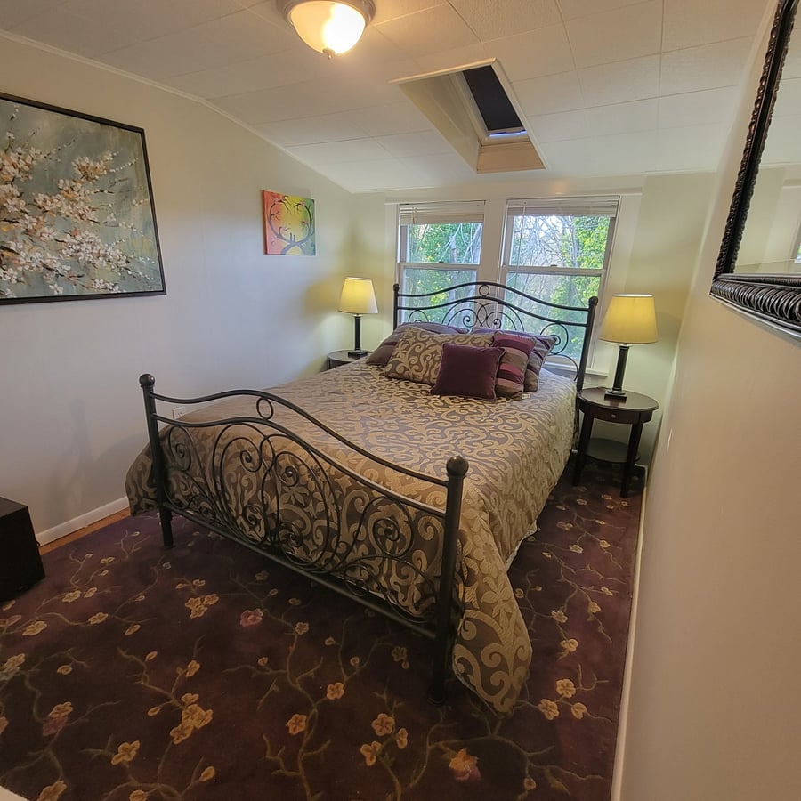Queen size bed with windows overlooking back yard. Blinds & shades can darken the room for peaceful sleep.