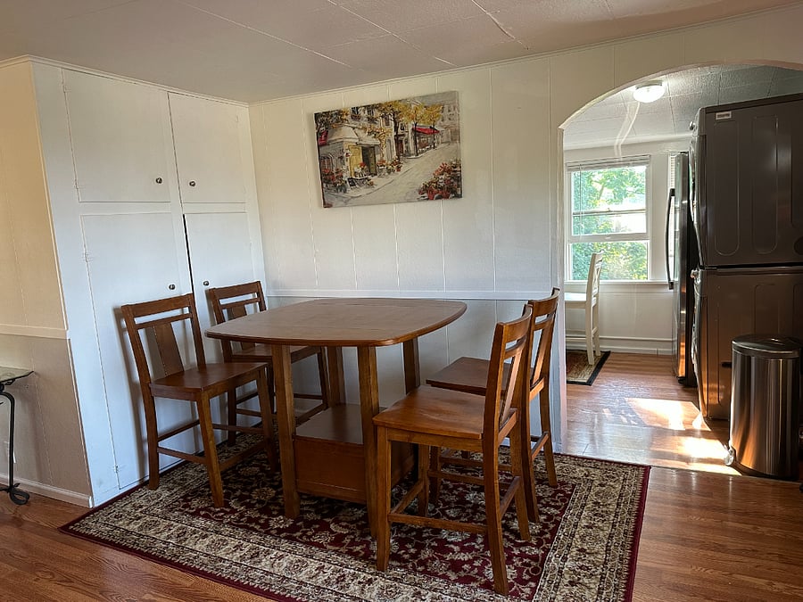 Dining Table with additional storage closets. Kitchen is visible behind & to the right. 
