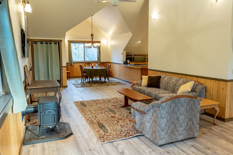 Open space layout with vaulted ceilings, large screen TV, gas parlor stove