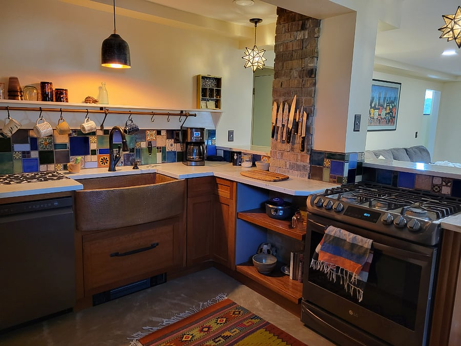 Kitchen has large copper sink, dishwasher, refrigerator with water and ice dispenser and gas range, as well as a large pantry.